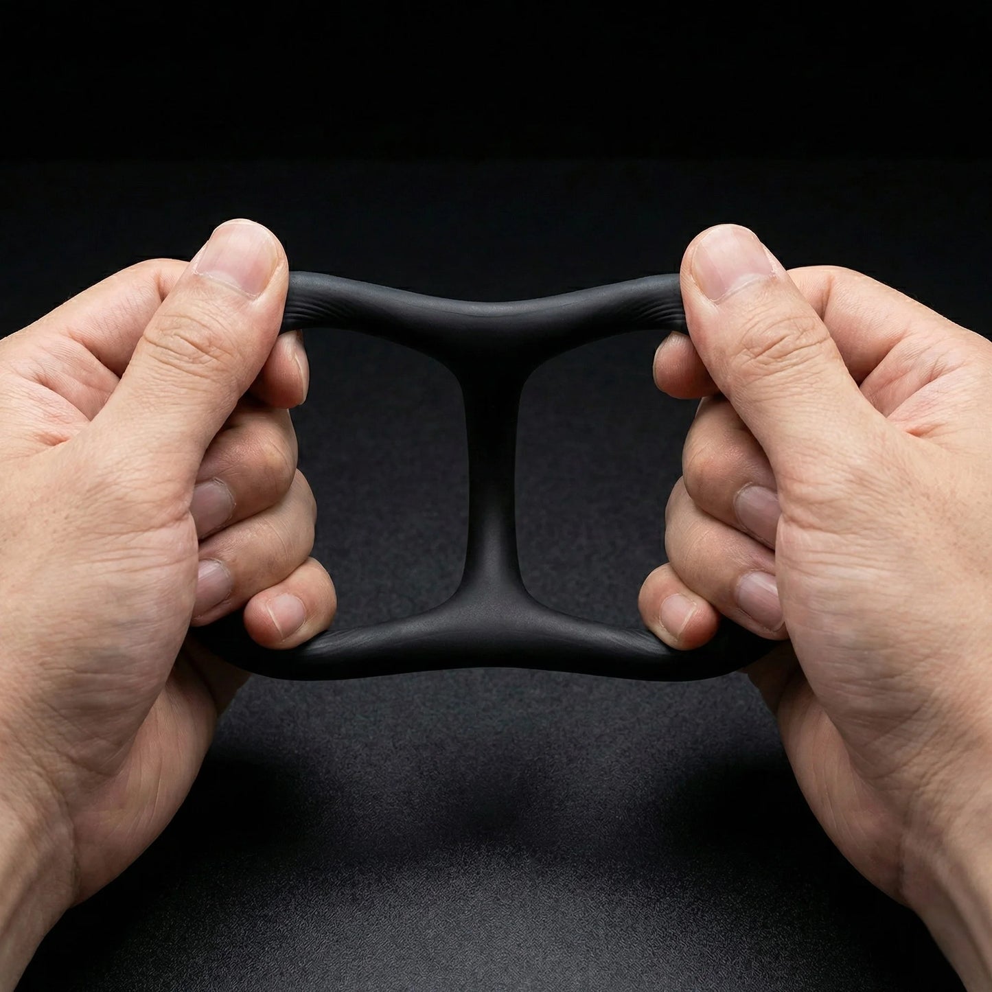 Hands stretching black Giddi Cerus flexible silicone cock ring demonstrating stretchability