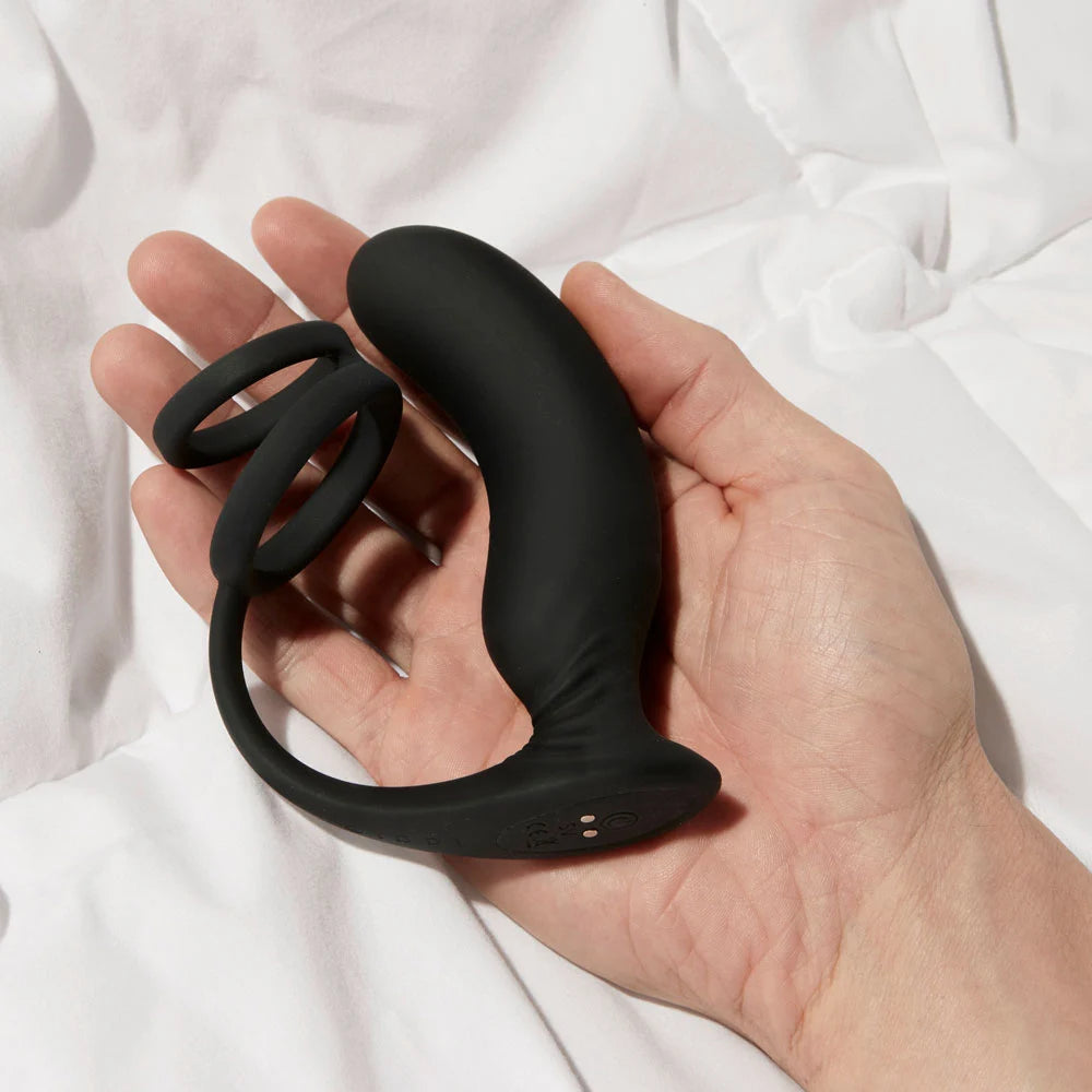 Vulcan vibrating prostate plug hand held on white bed comforter